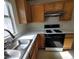 Kitchen with wooden cabinets, a gas stove, and a double sink at 5402 Night Swim Ln, Las Vegas, NV 89113