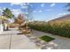 Backyard with patio, grass patch, and a mature tree at 8229 Flowing Rapids Ct, Las Vegas, NV 89131