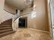 Grand entry with curved staircase and tile floors at 10008 Rolling Glen Ct, Las Vegas, NV 89117