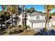 Two-story house with gray roof, three-car garage, and palm trees at 10008 Rolling Glen Ct, Las Vegas, NV 89117