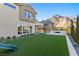 Landscaped backyard with artificial turf, fire pit, and spiral staircase at 11250 Torch Cactus Dr, Las Vegas, NV 89138