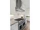 Stainless steel range, oven and vent hood in a white kitchen with granite counters at 11250 Torch Cactus Dr, Las Vegas, NV 89138