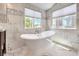 Elegant bathroom with freestanding soaking tub and marble tile at 1516 Via Salaria Ct, Henderson, NV 89052