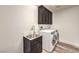 Laundry room with dark cabinets and stainless steel sink at 1516 Via Salaria Ct, Henderson, NV 89052