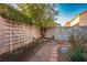 Small, private backyard with gravel pathway and trellis at 1555 Bent Arrow Dr, North Las Vegas, NV 89031