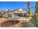 Sunny backyard featuring a trampoline and covered patio at 4705 Rockvale Dr, Las Vegas, NV 89103