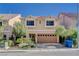 Tan two-story house with a two-car garage and nicely landscaped front yard at 5957 Pillar Rock Ave, Las Vegas, NV 89139