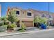 Two-story house with tan exterior, two-car garage, and landscaping at 5957 Pillar Rock Ave, Las Vegas, NV 89139