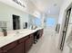 Bathroom featuring double sinks, large mirror, vanity space, soaking tub, and walk-in closet at 647 Wounded Star Ave, Las Vegas, NV 89178