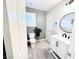 Well-lit bathroom features a white vanity, stylish round mirror, and a toilet next to a window with plantation shutters at 647 Wounded Star Ave, Las Vegas, NV 89178