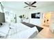 Bright primary bedroom featuring a ceiling fan, TV, decorative dresser, and ensuite bathroom access at 647 Wounded Star Ave, Las Vegas, NV 89178