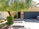 Front exterior featuring a two-car garage, stone accents, and mature desert landscaping for curb appeal at 647 Wounded Star Ave, Las Vegas, NV 89178