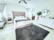 Airy main bedroom featuring neutral decor, a tufted headboard, plush area rug, and ensuite bathroom at 647 Wounded Star Ave, Las Vegas, NV 89178