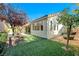 Landscaped backyard featuring artificial turf and mature shade trees against a clear sky at 11119 Cantoria Ct, Las Vegas, NV 89141