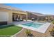 Spacious backyard features a pool, covered patio with lounge seating, BBQ, and lush landscaping at 1143 Tortoise Mountain Dr, Mesquite, NV 89034