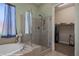 Serene bathroom featuring a soaking tub, glass-enclosed shower, and access to the walk-in closet at 1143 Tortoise Mountain Dr, Mesquite, NV 89034