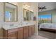 Bright bathroom with double vanity and large mirrors. The bedroom is visible through an open doorway at 1143 Tortoise Mountain Dr, Mesquite, NV 89034