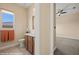 Well-lit bathroom featuring wood vanity, stylish fixtures, and neutral tiles at 1143 Tortoise Mountain Dr, Mesquite, NV 89034