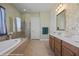 Bright bathroom with a soaking tub, glass-enclosed shower, double vanity and elegant floral wallpaper at 1143 Tortoise Mountain Dr, Mesquite, NV 89034