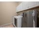 The laundry room has a washer and dryer and a stainless steel fridge with white cabinets for storage at 1143 Tortoise Mountain Dr, Mesquite, NV 89034