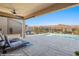 Inviting covered patio with ceiling fan, lounge chairs, barbecue and a view of the sparkling pool at 1143 Tortoise Mountain Dr, Mesquite, NV 89034