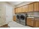 Bright laundry room, washer, dryer, and ample cabinetry at 248 N Milan St, Henderson, NV 89015