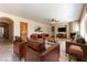 Virtually staged living room with brown leather furniture, a fireplace, and a built-in entertainment center at 5024 Crown Cypress St, Las Vegas, NV 89149