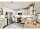 Modern kitchen with white cabinets, stainless steel appliances, and granite countertops at 7000 W Rome Blvd, Las Vegas, NV 89131