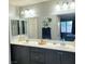 Double vanity bathroom with modern dark cabinets and a large mirror at 7914 Torreys Peak St, Las Vegas, NV 89166