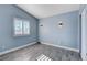 Light blue bedroom with wood-look flooring, window with shutters, and closet at 8214 Mt Brodie Cir, Las Vegas, NV 89145