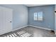 Light blue bedroom with wood-look flooring, window with shutters, and closet at 8214 Mt Brodie Cir, Las Vegas, NV 89145