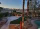 Landscaped backyard with a pool, basketball court, and palm trees at 9012 Alpine Peaks Ave, Las Vegas, NV 89147