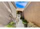 Pathway to the front door of a tan house with lush landscaping at 9452 Gold Mountain Dr, Las Vegas, NV 89134