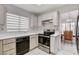 Kitchen with white cabinets, black appliances, and view to dining room at 9452 Gold Mountain Dr, Las Vegas, NV 89134