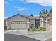 Tan stucco home with a two-car garage and nicely landscaped front yard at 1774 Franklin Chase Ter, Henderson, NV 89012