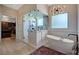 This ensuite bathroom features a soaking tub, modern lighting, and a luxurious glass enclosed shower at 2111 Bogart Ct, Las Vegas, NV 89117