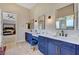 This ensuite bathroom features dual sinks with marble countertops, blue cabinets, and modern finishes at 2111 Bogart Ct, Las Vegas, NV 89117