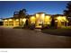 Stunning exterior view of home with multiple garage bays, beautiful landscaping, and impressive architectural details at dusk at 2111 Bogart Ct, Las Vegas, NV 89117