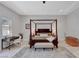 This main bedroom features tile floors, tray ceilings, a workspace, and a four-poster bed at 2111 Bogart Ct, Las Vegas, NV 89117