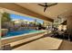 Inviting backyard pool with stone waterfall feature and covered patio with ceiling fans and outdoor dining set at 2111 Bogart Ct, Las Vegas, NV 89117