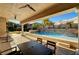 Backyard pool with stone waterfall feature and covered patio with ceiling fans and outdoor dining set at 2111 Bogart Ct, Las Vegas, NV 89117