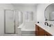 Bathroom with enclosed bathtub/shower, single sink, and shuttered windows at 3709 Citrus Heights Ave, North Las Vegas, NV 89081