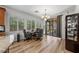 Bright dining area featuring a chandelier, wood-look floors, and large windows with shutters for natural light at 3709 Citrus Heights Ave, North Las Vegas, NV 89081