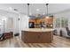 Modern kitchen features a center island with granite countertops, pendant lighting, and wood-look floors at 3709 Citrus Heights Ave, North Las Vegas, NV 89081