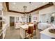 This open kitchen features white cabinets, stainless steel appliances, wooden beams, pendant lighting, and a cooking island at 480 Heritage Bridge Ave, Henderson, NV 89011