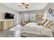 This main bedroom features neutral walls, a ceiling fan, a TV, and an ensuite bathroom at 480 Heritage Bridge Ave, Henderson, NV 89011