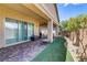 Charming covered patio with brick flooring, artificial grass, and outdoor seating, perfect for relaxing at 480 Heritage Bridge Ave, Henderson, NV 89011