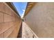 Narrow side yard featuring a brick pathway and a beige privacy wall, providing a functional outdoor space at 480 Heritage Bridge Ave, Henderson, NV 89011