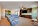 Living room with sectional sofa, built-in entertainment center, and large TV at 2452 Blair Castle St, Henderson, NV 89044