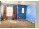 Bedroom with blue walls, carpeting, and window with curtains allowing lots of natural light at 6216 Pangea Ave, Las Vegas, NV 89139
